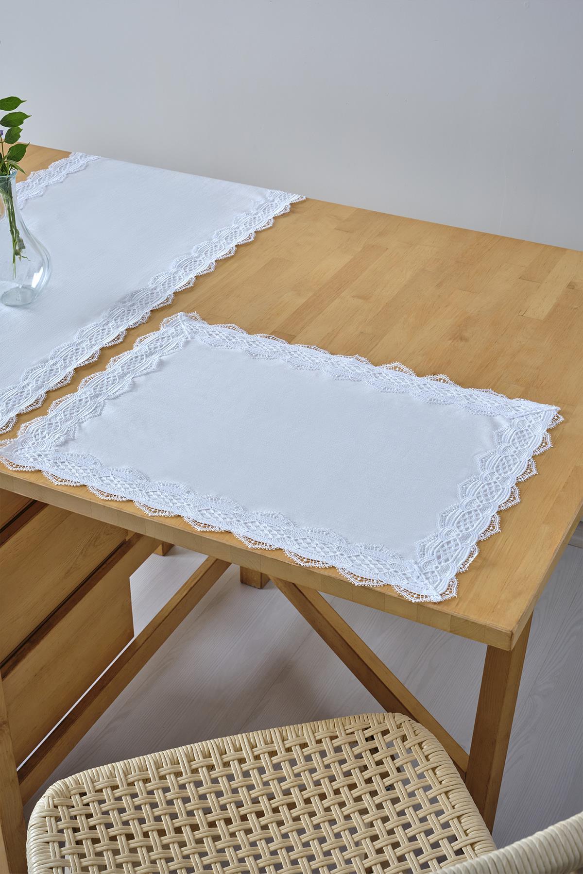 Individual de mesa blanco con borde de encaje, decoración de mantel sobre mesa y silla de madera