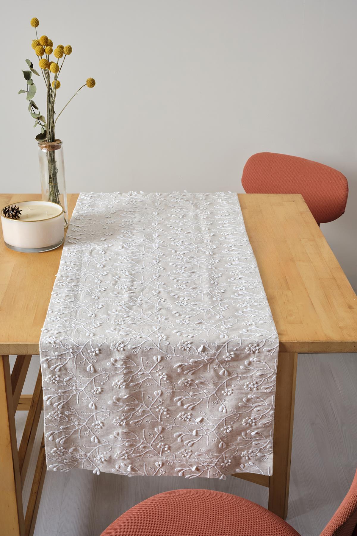 Mantel con bordado de encaje, presentación decorativa sobre una mesa de madera natural