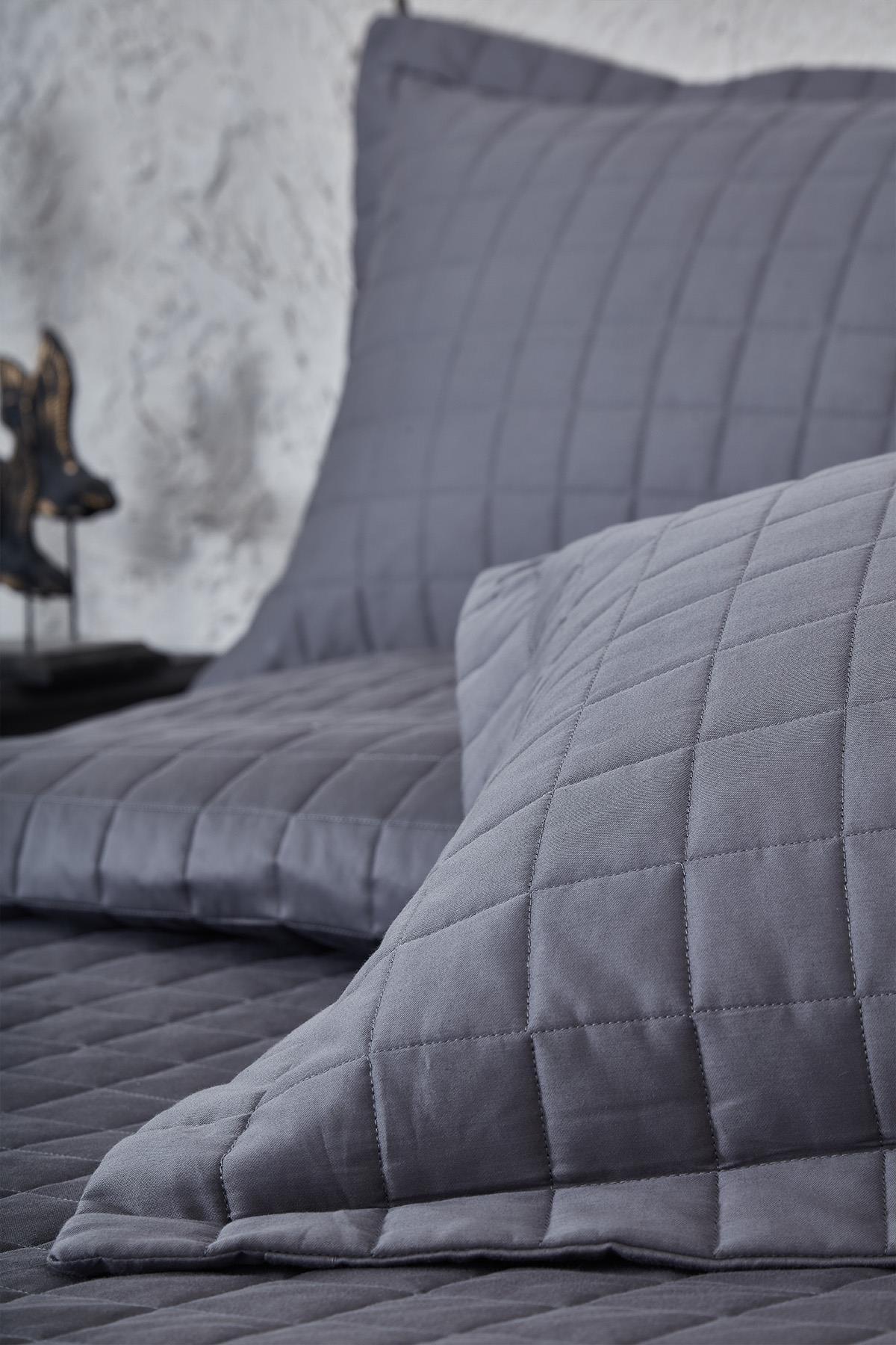 Cubrecama matrimonial capitoné gris con almohadas, textiles modernos para dormitorio