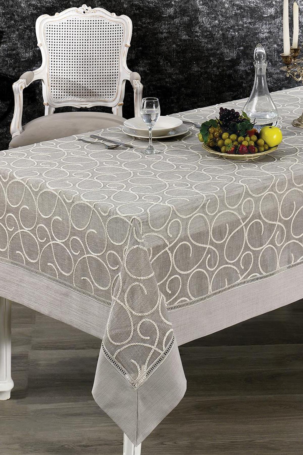 Mantel estampado antimanchas, dispuesto en una mesa elegante con un frutero y una jarra de cristal.
