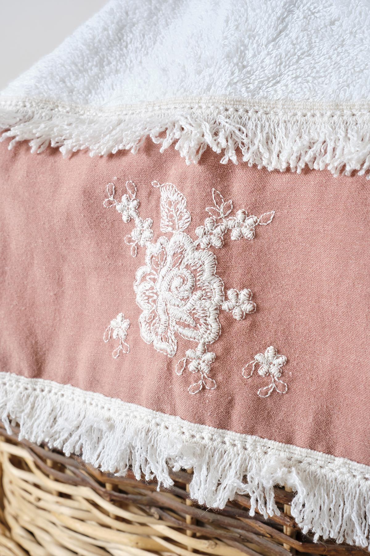 Primer plano de toalla de baño rosa y blanca con encaje y borlas