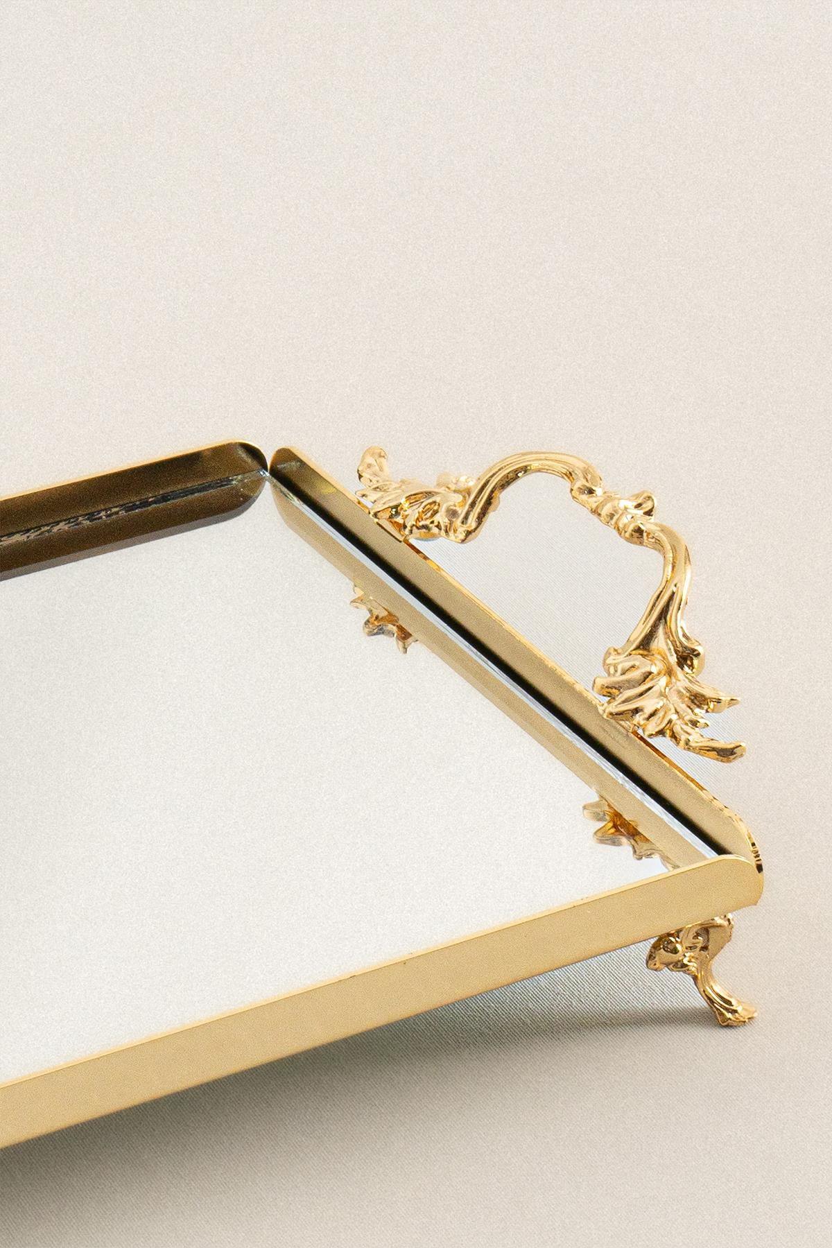 Bandeja pequeña con elegantes asas doradas, diseño decorativo con patas y superficie de espejo rectangular.