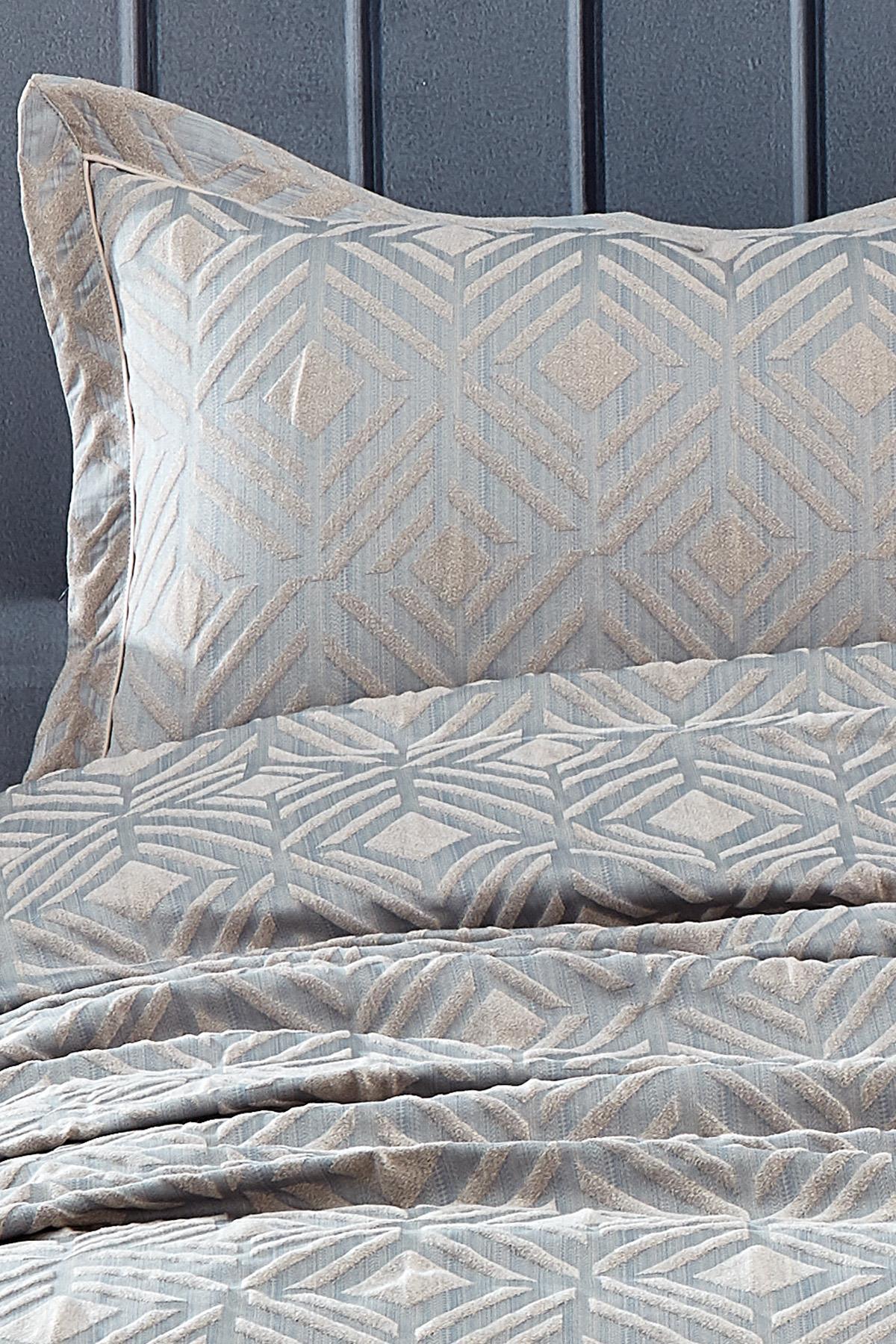 Colcha doble y almohada de jacquard con patrón geométrico gris.