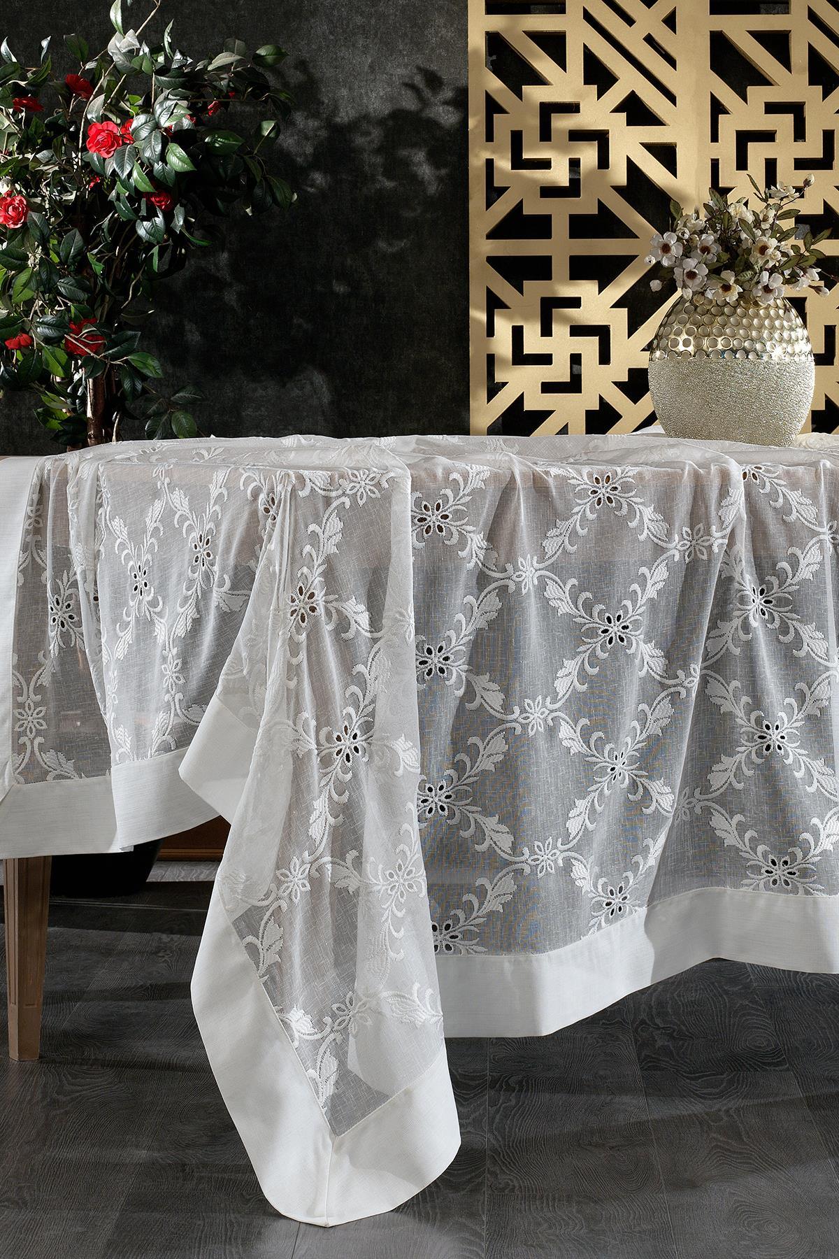 Mantel de mesa blanco, sin arrugas y antimanchas, con diseño de encaje floral, sobre una mesa con decoración moderna