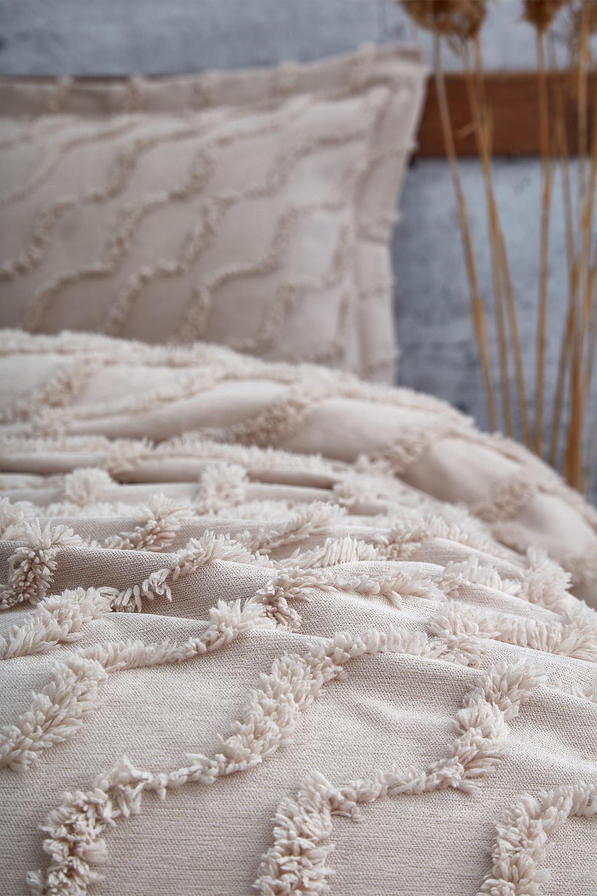 Colcha individual de color beige con textura de lino y detalle de borlas, incluye funda de almohada