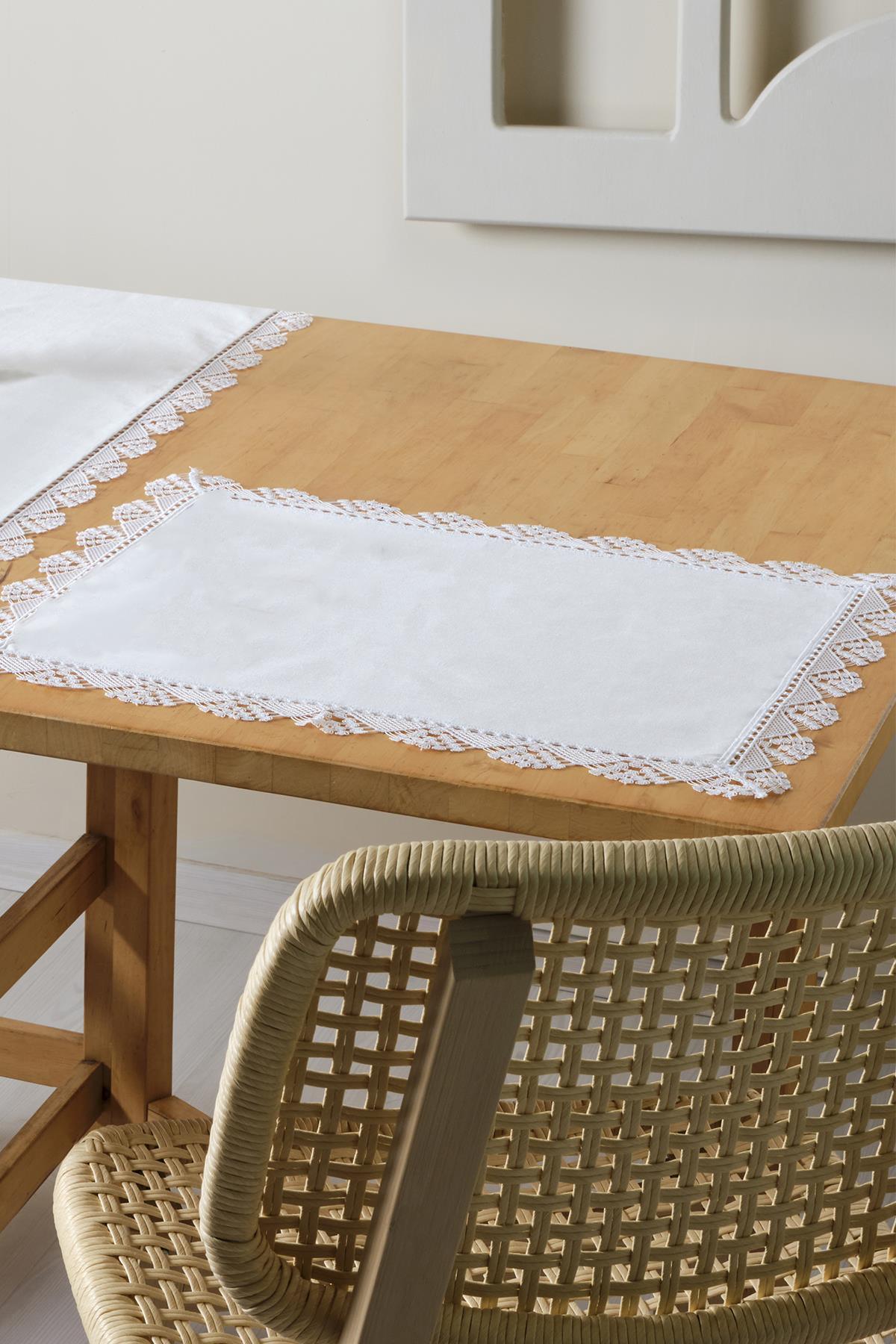 Individual de mesa blanco con borde de encaje, elegante decoración de mesa sobre una mesa de madera