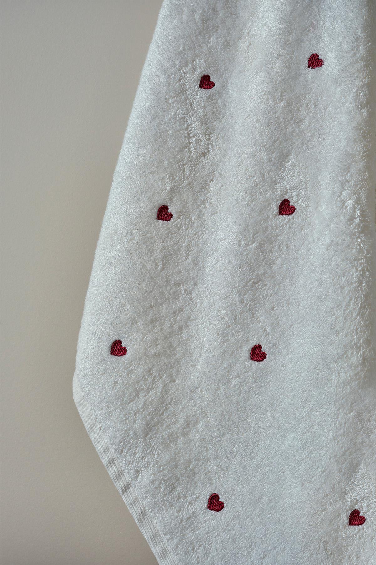 Toalla blanca con estampado de corazones rojos, elegante y cómoda