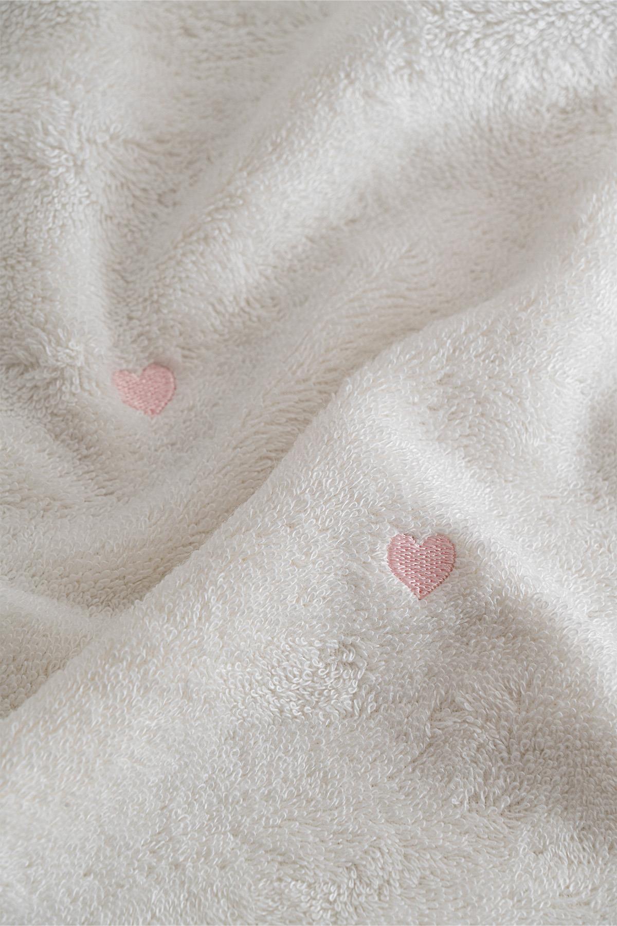 Toalla blanca suave con detalle de corazón rosa, para una vida cómoda y elegante