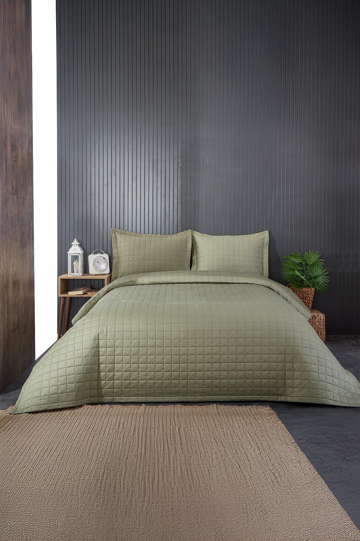 Colcha doble acolchada de color verde para un aspecto decorativo en un dormitorio moderno