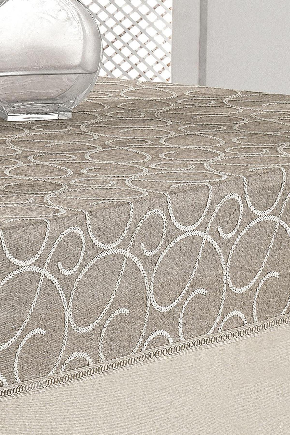 Mantel rectangular de color beige con estampado, antimanchas y fácil de limpiar, con un jarrón sencillo sobre la mesa.