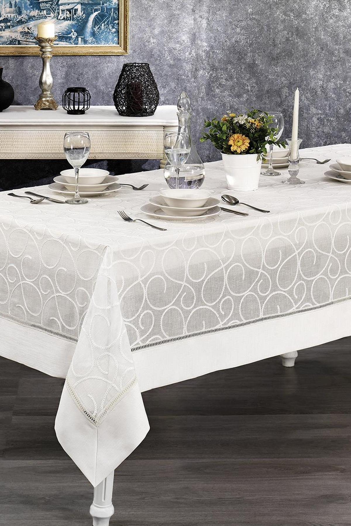 Mantel blanco antimanchas y sin arrugas sobre una mesa con un arreglo moderno y elegante