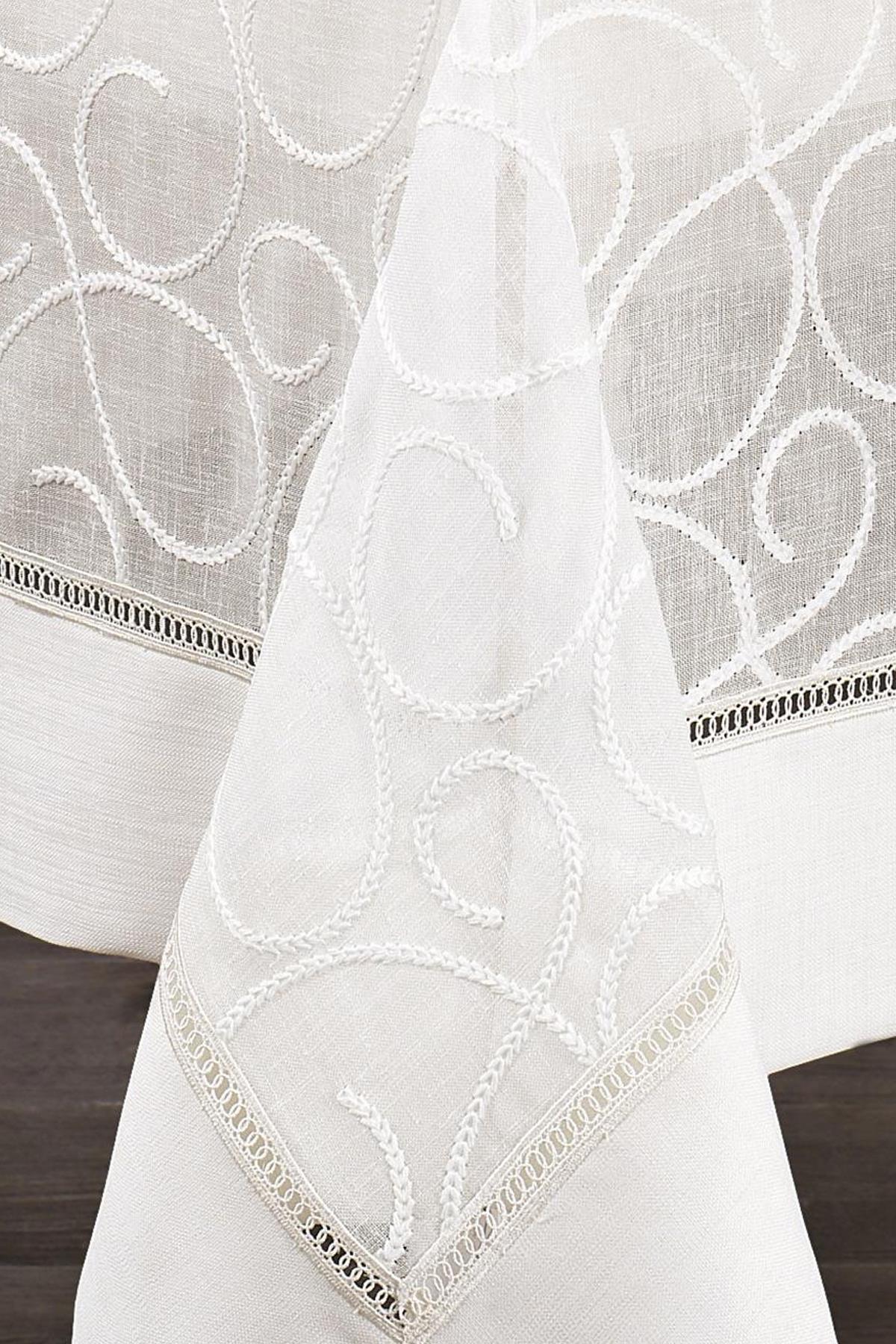 Mantel antimanchas blanco con estampado, tela de fácil cuidado y detalle decorativo en el borde.