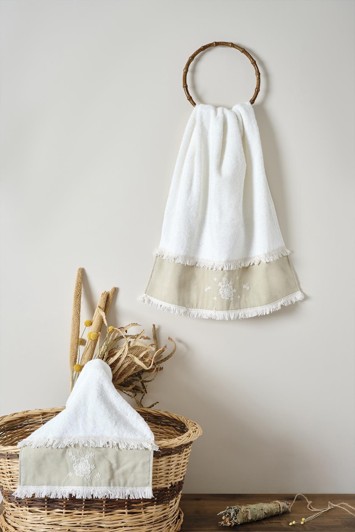 Toalla de mano de algodón color crema con detalles de encaje, presentada con una cesta y flores secas decorativas.