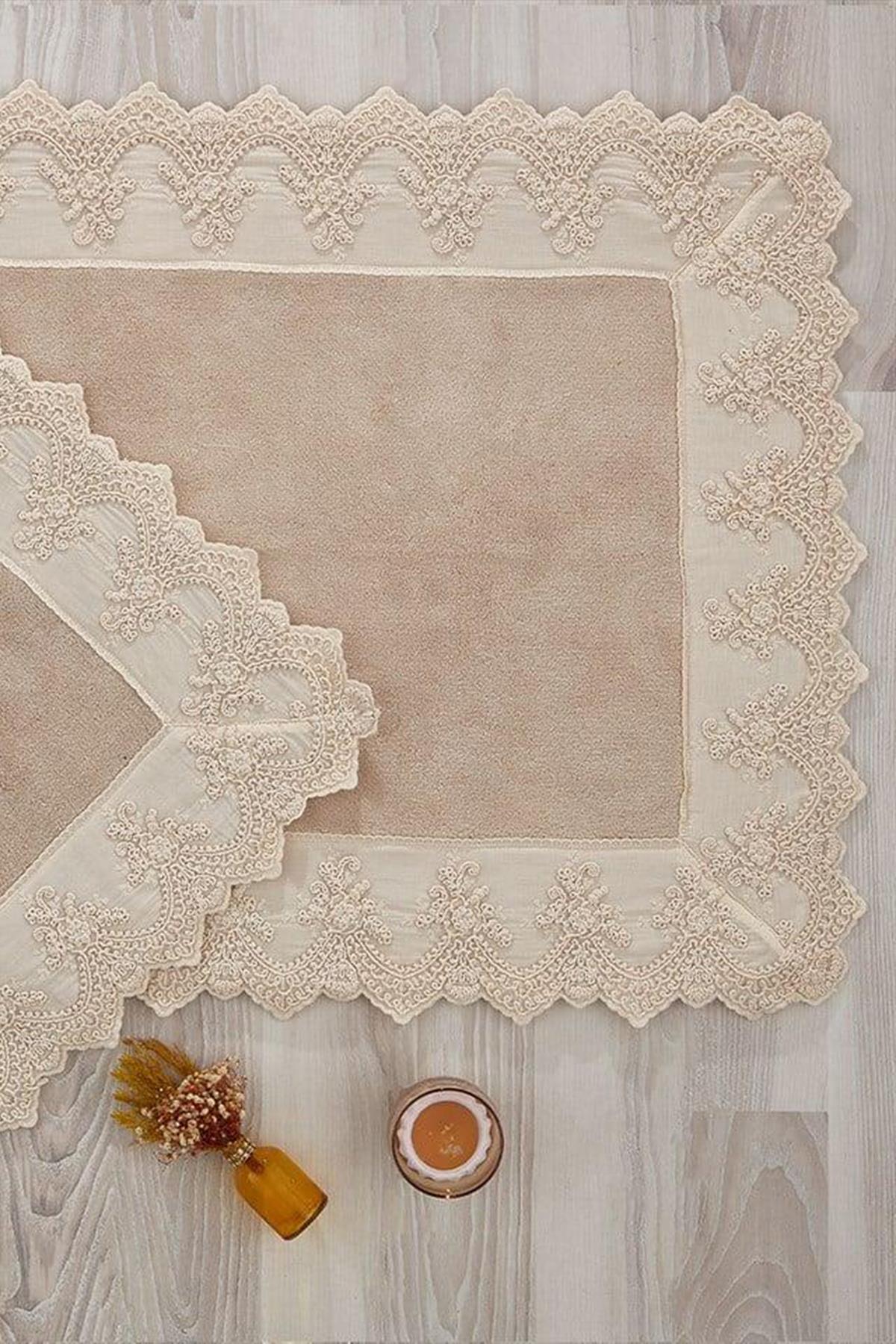 Juego de 2 alfombrillas rectangulares de color crema con bordado de encaje, dispuestas de forma decorativa sobre un suelo de madera