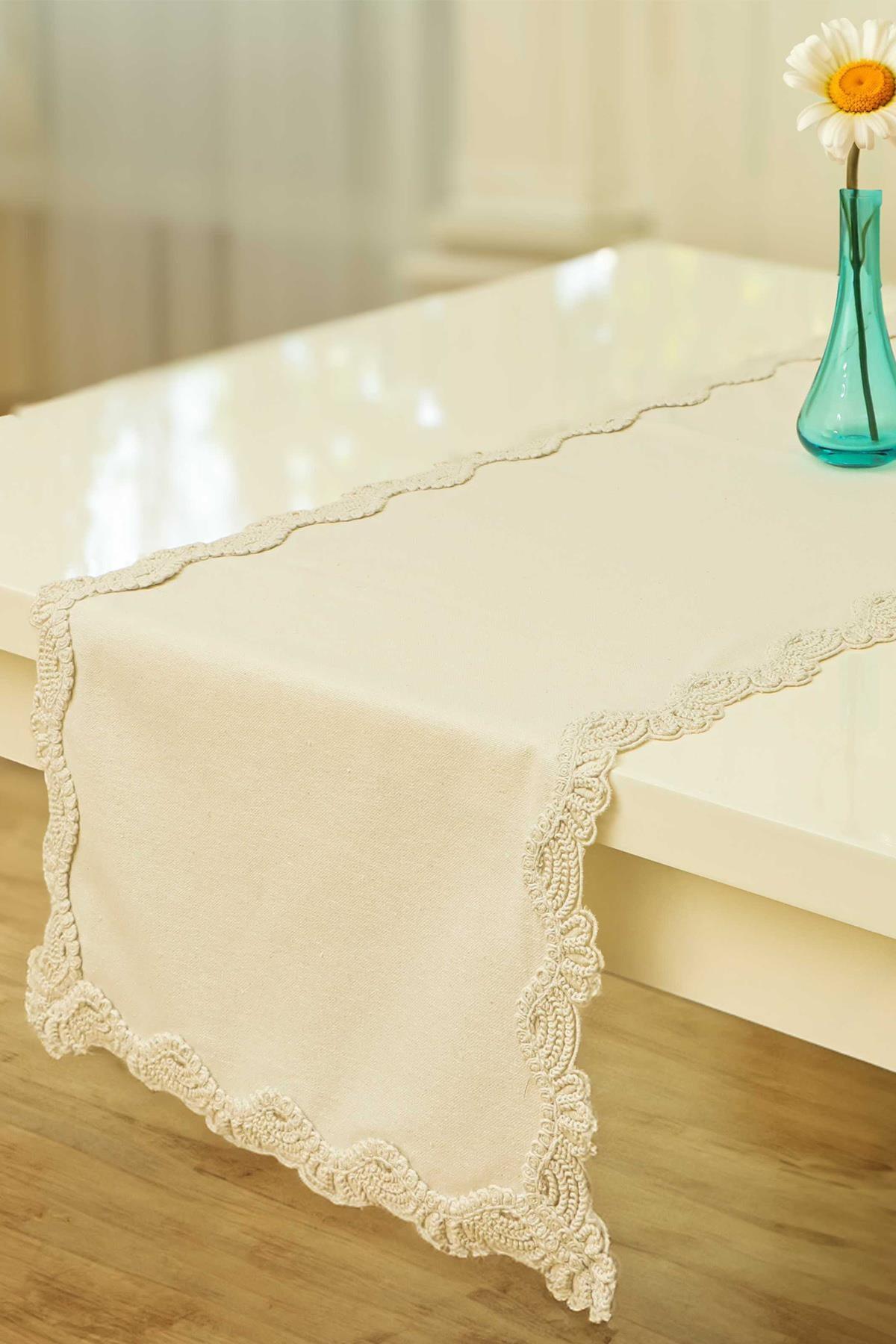 Camino de mesa color crema con borde de encaje, mantel decorativo y elegante sobre mesa blanca