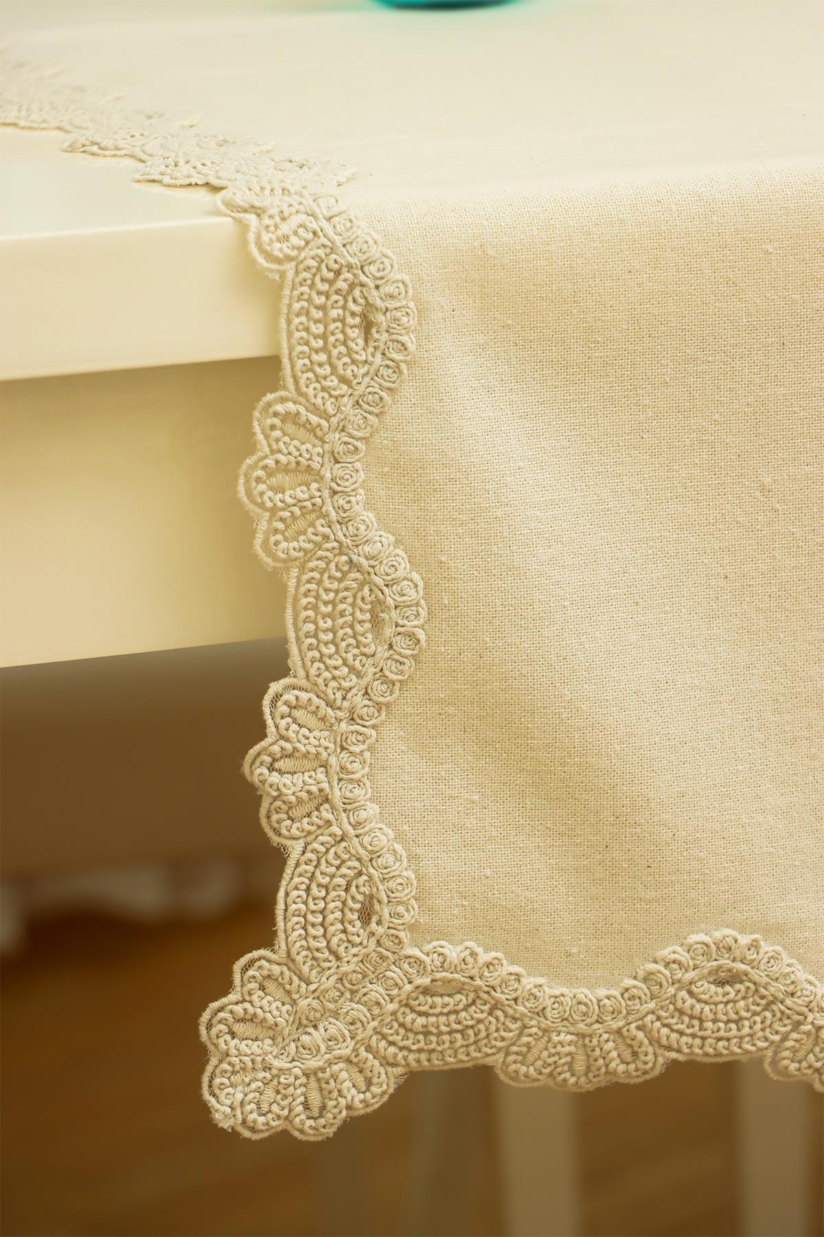 Mantel de color crema con elegantes detalles de encaje en los bordes, decoración de mesa moderna.